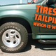 A photo of the front left tire on a green SUV with the caption "tires or tailpipes, which is worse?"